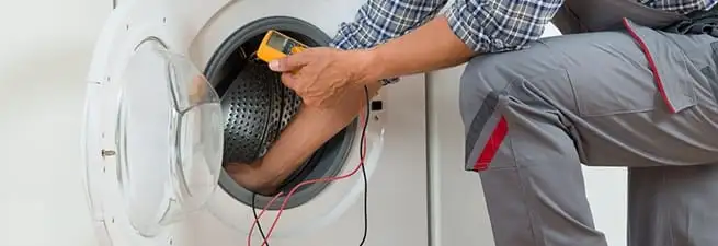 Dryer repair technician inspecting and repairing a clothes dryer in Ogden, UT