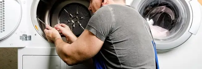Dryer repair technician fixing a clothes dryer drum in Ogden, UT
