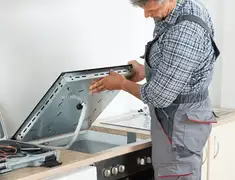Appliance repair technician installing a built-in cooktop in Ogden, UT