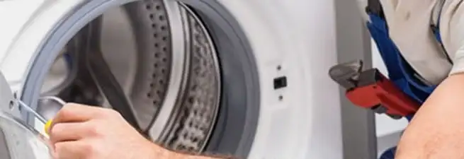 Appliance technician repairing a clothes dryer drum and internal parts in Ogden, UT