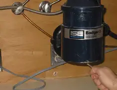 Garbage disposal repair technician tightening the mounting ring under a sink in Ogden, UT