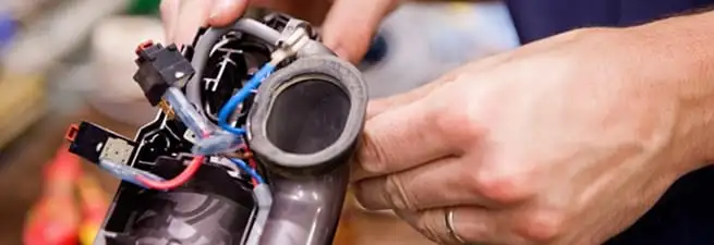 Vacuum repair technician reconnecting wiring and components in Ogden, UT
