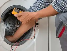 Washing machine repair technician testing a front-load washer with diagnostic tools in Ogden, UT
