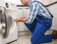 Washing machine repair technician servicing a front-load washer in Ogden, UT