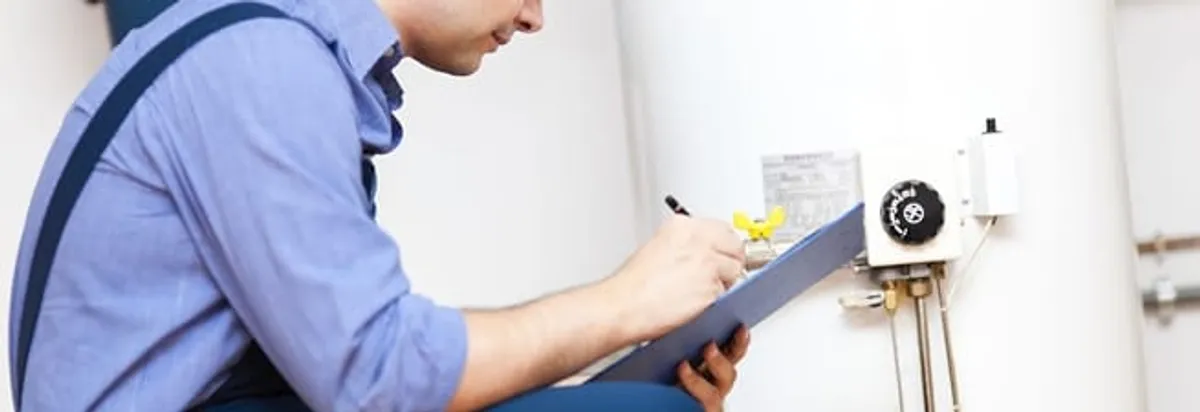 Water heater repair technician inspecting the unit and recording service notes in Ogden, UT