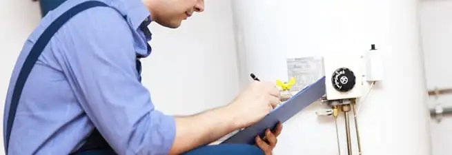 Water heater repair technician inspecting the unit and recording service notes in Ogden, UT